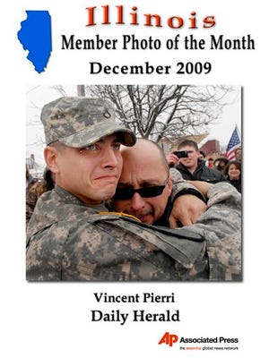 In this Dec. 27, 2009, file photo, U.S. Army Pfc. Adam Trost, left, of Grayslake, Ill. hugs his father, Paul Trost, as he returned home after two tours in Iraq. Trost was surprised to find that family and friends had completed a $25,000 makeover on his sports car. (AP Photo/Daily Herald, Vincent Pierri, File)