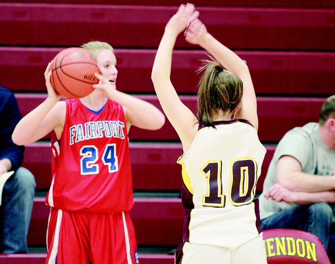 Lindsay McKinnon 24 who is a senior and plays Guard for Fairport looks for an open player while number 10 Jenna Cuddeback of Mendon tries to block her passing to an open Player. Fairport won the game over Mendon