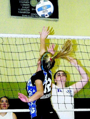 Dolgeville Blue Devil Marissa Mowers swats the ball over the net with Kirstie Green (right) blocking for Little Falls Jan. 6.