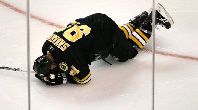 Boston Bruins center Marc Savard drops to the ice after injuring his knee against the Chicago Blackhawks.