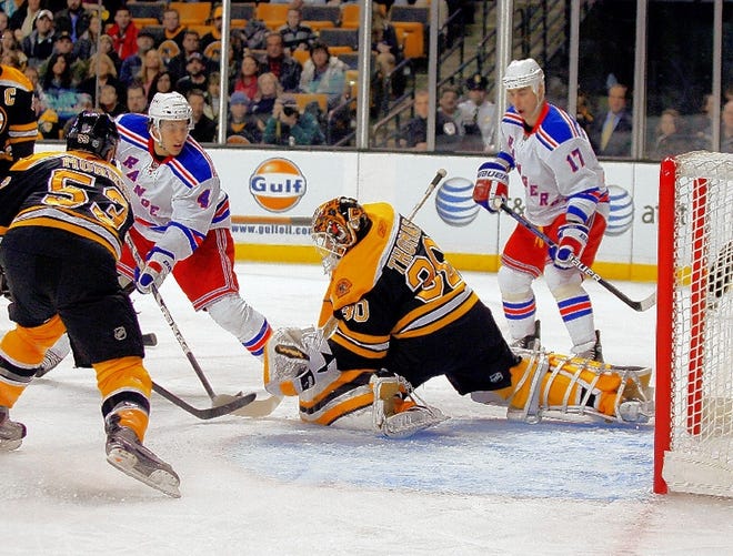 New York's Michael Del Zotto (4) scores a goal past Boston goalie Tim Thomas (30) as Rangers' Brandon Dubinsky (17) and Bruins' Derek Morris (53) defends in the first period on Saturday afternoon in Boston.