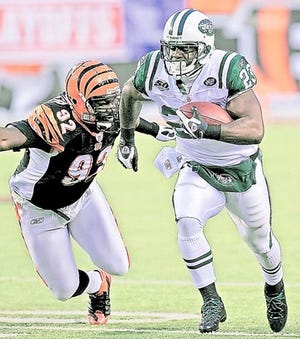 New York Jets running back Shonn Greene runs for a 39-yard touchdown past Cincinnati Bengals defensive end Frostee Rucker in Saturday's playoff game in Cincinnati. By DAVID KOHL, The Associated Press
