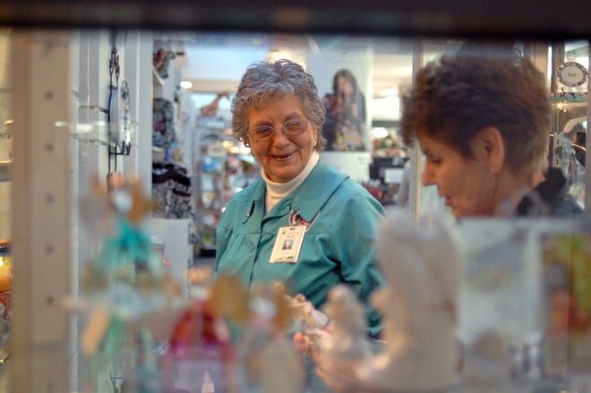 Candler Hospital Gift Shop volunteer worker Nell Redmond, left, assists customer Toni Jackson with a gift from their display case. (John Carrington/Savannah Morning News)