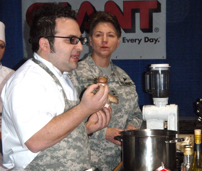 Chef Eli Kirshtein, recent ‘Top Chef’ contestant, shows a crowd at the Pennsylvania Farm Show in Harrisburg locally grown portabella mushrooms. Kirshtein made a creamy mushroom soup, while Maj. Gen. Jessica Wright from the Pennsylvania National Guard supervised Saturday’s demonstration.