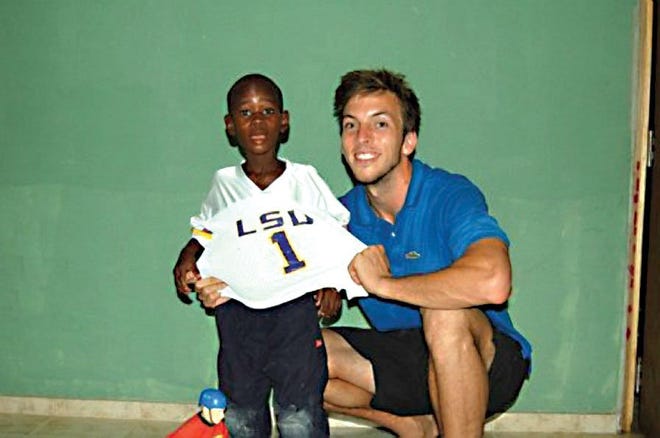 Jeremy Schurke with an orphan in Haiti. He helps operate an orphanage there and was caught in the earthquake.
