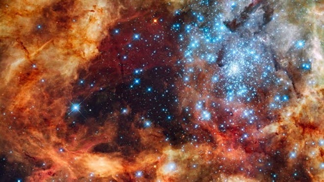 This image provided by NASA's Hubble Space Telescope Tuesday Dec. 15, 2009 shows hundreds of brilliant blue stars wreathed by warm, glowing clouds. The festive portrait is the most detailed view of the largest stellar nursery in our local galactic neighborhood. The massive, young stellar grouping, called R136, is only a few million years old and resides in the 30 Doradus Nebula, a turbulent star-birth region in the Large Magellanic Cloud (LMC), a satellite galaxy of our Milky Way. There is no known star-forming region in our galaxy as large or as prolific as 30 Doradus.