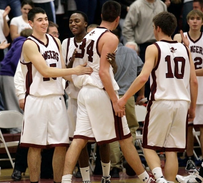 Westborough's #15 Pat Hession and #20 Isaac Mutesasira give #34 Nate Foy congrats as the team comes off the floor with the win, Thursday night against Algonquin Regional at Westborough H.S.