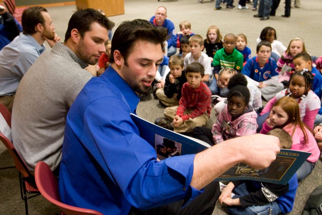 Cubs pitcher Justin Berg reads to a group of students from Owen Marsh Elementary School on Thursday during the Cubs Caravan at the Abraham Lincoln Presidential Library. Pitcher Randy Wells, center, and catcher Koyie Hill also were on hand.