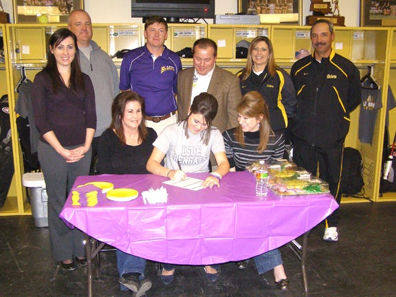 St. Amant’s Melanie Parker signs a softball scholarship to LSU-Eunice Friday afternoon in the Lady Gators’ locker room. Pictured from left, back row: St. Amant head coach Scott Nielson, LSU-Eunice head coach Andy Lee, St. Amant principal Steve Westbrook, St. Amant assistant athletic director Celeste Small and assistant coach Troy Templet. Front row: sister Ashley Hernandez, mom Stephanie Miller, Parker and sister Bridget Hernandez.