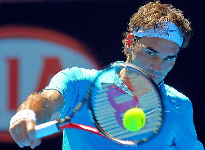 Roger Federer returns to Igor Andreev during their Men's singles first round match at the Australian Open in Melbourne, Australia, on Tuesday.