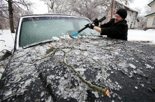 Shawn Munyon, of Des Moines, Iowa, scrapes ice off the windshield of his truck, Wednesday, in Des Moines, Iowa. (AP Photo/Charlie Neibergall)