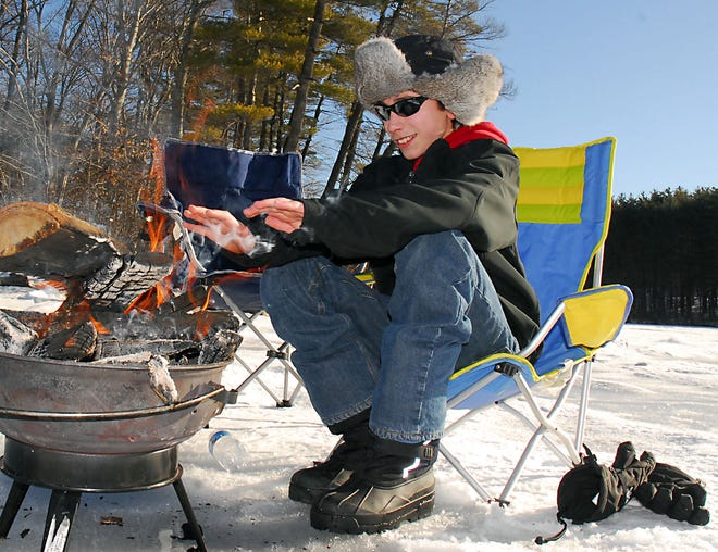 Jake Holdcraft, 13, of Foxborough, tries to keep his hands warm while enjoying a day out on the ice during the Woodville Rod and Gun Club's Ice Fishing Derby on Lake Whitehall in Hopkinton yesterday morning.