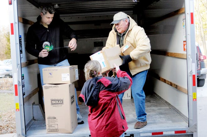 Michon Giffee hands a box of medical supplies to Karl Althage Sunday as Dennis Baggett helps prepare the cargo for transport to Haiti. Karl’s wife, Karen Althage, and Baggett are members of a group traveling to help with relief efforts in the wake of the devastating Jan. 12 earthquake.
