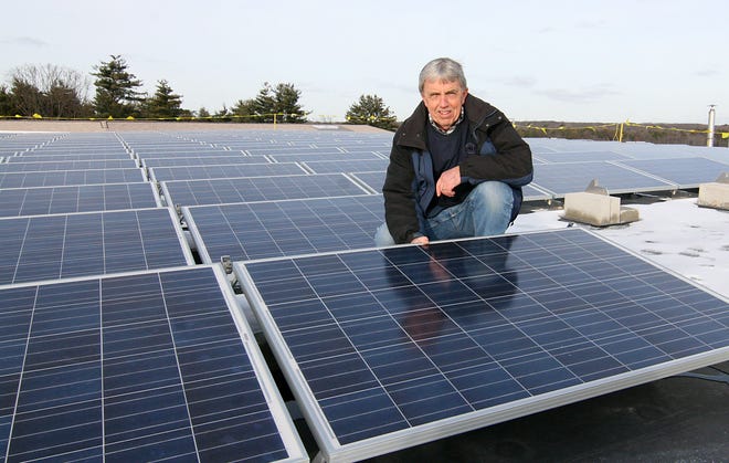 Bob Hebden shows one of the 660 solar panels installed on the roof of Medway High School. Hebden said the panels are slated to go online in mid-February, and will generate approximately one-third of the energy the building uses.