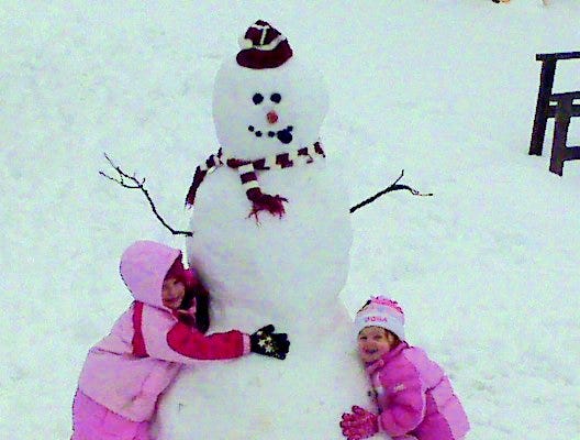 Jaylee, 5, and Jacey, 2, Hasten, the daughters of Josh and Gena Hasten of Monmouth, with their snowman. The girls and their dad, Josh, built the snowman in the backyard.