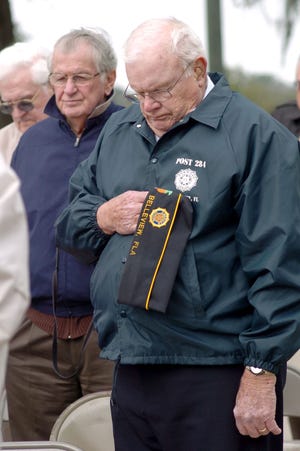 Lee Rush, a World War II veteran, holds his hat in prayer during the Memorial Ceremony of the Four Chaplains on Sunday.