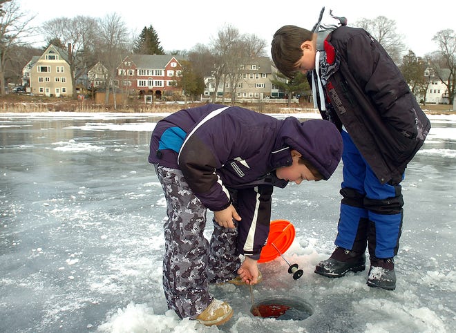 Joshua Lorenzo, left, of Millville, 9, and his brother Jeremy did some ice fishing with their father in Hopedale on Tuesday. Here they check the depth of the ice which is about a foot thick.