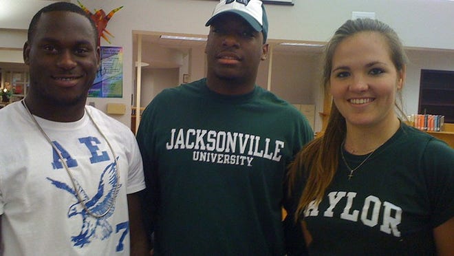 Matt Elam (left), who returned to Dwyer to sign his national letter of intent with Florida, stands with Charles Dowdy, who signed with Jacksonville, and softball player Claire Hosack, who signed with Baylor.