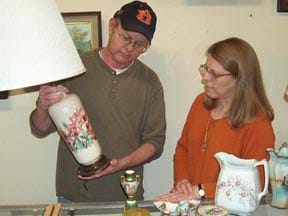 Tim and Debbie Galloway, owners of Gadsden Sports Cards and Antiques, look over some of their merchandise as they get ready for this weekend’s 43rd annual Altrusa Antique Show and Sale.