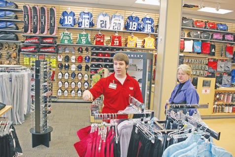 Store Manager Matt Welch helps customer Marian Poteat with her purchases at Hibbett Sports.