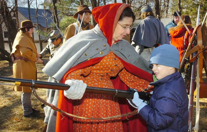 Betty Dion of Cumberland, R.I., lets Henry Hall, 6, of Milton hold a Civil War rifle during a birthday celebration for Abraham Lincoln at the Forbes House Museum in Milton. The celebration included a concert and re-enactors.