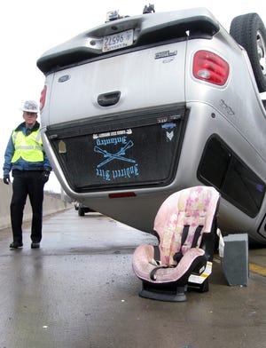 A Kansas Highway Patrol trooper investigates a one-vehicle accident on Interstate 70 at Fairlawn Road that injured a man and woman inside the SUV but not the 8-month-old baby riding in the car seat left behind at the scene.