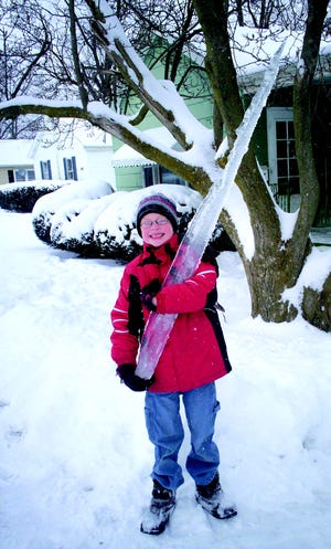 Ryan Bowman 8, with the “monster icicle” he found on the side of his house in Monmouth.