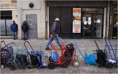 Patrons line up grocery carts to wait for the opening of a food pantry in Harlem. Since Mayor Michael R. Bloomberg took office, city food stamp rolls have doubled.