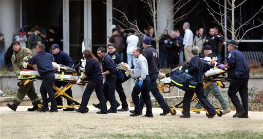 Two shooting victims are taken from the Shelby Center on the campus of the University of Alabama to an ambulance after multiple people were shot in Huntsville, Ala, Friday Feb. 12, 2010. Officials at the University of Alabama's Huntsville campus say three people have been killed and another injured in a campus shooting.