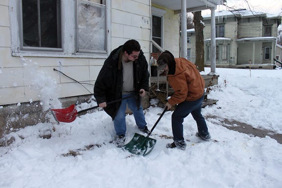 Ionia residents Ryan Gillman and Cory Young clear their walkway Friday evening. “It’s a very cold job,” said Young. While they didn’t mind the shoveling, they both said they disliked the frigid temperature.