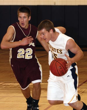 Pewamo-Westphalia’s Austin Strong makes a move past Potterville’s Brad Portt Friday night during the first quarter of the Pirates game against the Vikings.