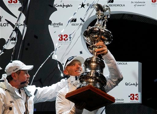 BMW Oracle Racing helmsman's James Spithill, right, raises the trophy next to the team's owner Larry Ellison, left, after winning the 33rd America's Cup against Alinghi in Valencia, Spain, on Sunday, Feb. 14, 2010.