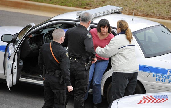 Amy Bishop is detained by Huntsville, Ala. police, Friday, Feb 12, 2010, on the University of Alabama in Huntsville campus in Huntsville, Ala. A woman opened fire during a biology faculty meeting at the University of Alabama's Huntsville campus Friday, killing three people and injuring three others, officials said. A man was also being detained.