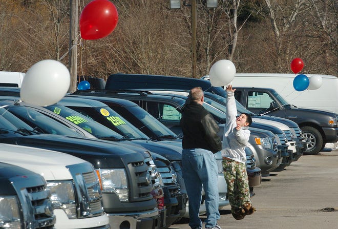 Shoppers look for deals at Jannell Ford in Hanover. Tommy Foley, 8, Quincy, jumps to reach a balloon which decorates the autos in the lot He was car shopping with grandparents 
Roger and Patty Spring of Hanover, who were looking for a used Ford Explorer.