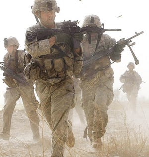 Tyler Hicks/The New York Times via The Associated Press
U.S. Marines, one with a cigarette clenched in his teeth, take cover from enemy fire in Marja, Afghanistan, on Sunday. U.S. Marines and Afghan troops came under attack in the Taliban stronghold in Helmand Province on Sunday.