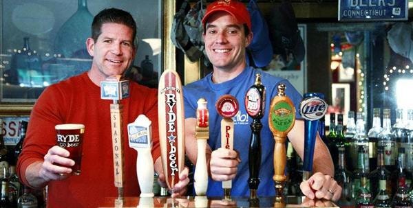 Ned LaFortune, left, and and Land Ho! manager John Murphy Jr. show off the establishment's row of taps. The Ryde pull is the one shaped like a standup paddle board.
