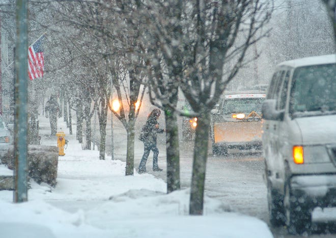 A pedestrian ventures into Washington Street in Weymouth during Tuesday’s storm, which made walking and driving a bit dicey.