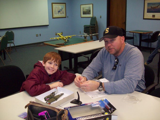Hunter Goodwin, 8, and his dad, Joel, prepare to put a Flying Tiger model together.