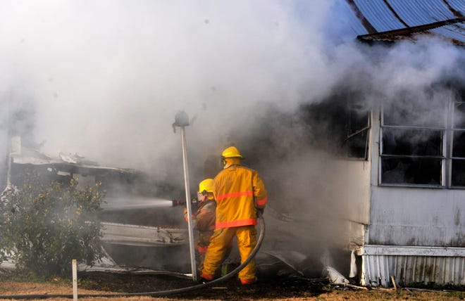 Firefighters put water on a house fire on Cowan Avenue Wednesday morning. (Steve Bisson/Savannah Morning News)