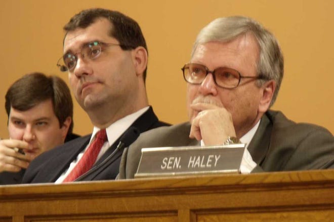 Kansas State Sen. Tim Owens (right, sitting at an angle behind another senator's name placard) called the 5 percent salary cut approved by both house of the Legislature Thursday a "vindictive" slap at Supreme Court judges who ruled for the state's K-12 schools in a constitutional challenge over state funding.