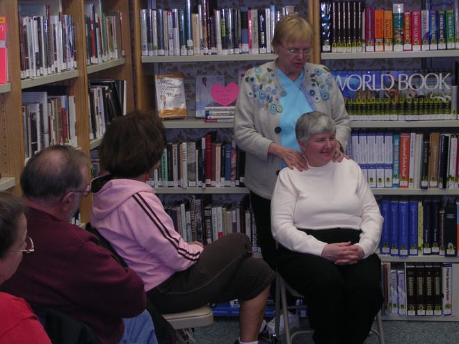 Licensed massage therapist Lucy Tomasko of Canton’s Renew You shows her massage therapy techniques to a group as Farmington librarian Barb Love serves as her subject. The program is part of the library’s “Afternoon Tea at Your Library” series.
