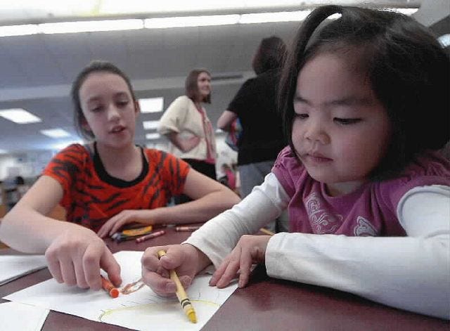 John Huff/Staff photographer
Isabella DiBello, 12, helps her buddy Jaelyn Brown, 6, as she illustrates a children's book at Dover Middle School Thursday.