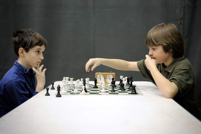 Zane Durante, left, watches as defending champion Grant Roulier prepares to move a piece during a tie-breaking championship match in the Columbia Open Chess Tournament Saturday at Gentry Middle School for elementary and middle school students in Columbia.