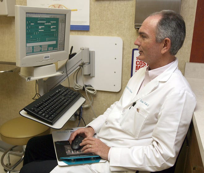 Eric Voth, a Topeka internist, works on the electronic medical record of a patient at Cotton-O'Neil Clinic. The clinic's medical records are being maintained using the NextGen system, which has been used at the clinic since 1998.