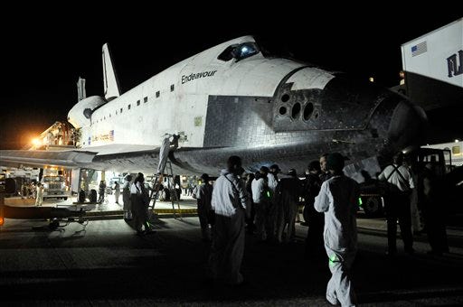 NASA technicians work on space shuttle Endeavour after it's landing at the Kennedy Space Center in Cape Canaveral, Fla., Sunday, Feb. 21, 2010, after a 14-day mission to the International Space Station.