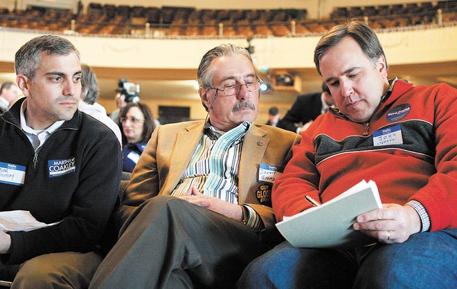 John Stefanini, right, a Framingham resident and former Democratic state representative, confers with Dennis Giombetti, center, and Adam Sisitsky, left, during the Framingham Democratic caucus held yesterday afternoon at Nevins Hall in the Memorial Building.