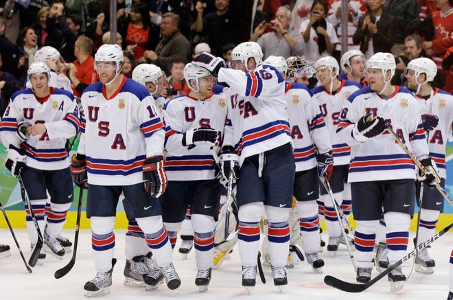USA's Ryan Malone (12), Joe Pavelski (16) and Ryan Whitney (19), center, congratulate one another after beating Canada 5-3 a men's preliminary round ice hockey game at the Vancouver 2010 Olympics in Vancouver, British Columbia, Sunday, Feb. 21, 2010. (AP Photo/Chris O'Meara)