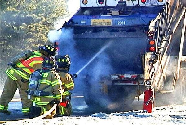 Firefighters douse flames in the back of an Allied Waste trash truck on Route 6 eastbound between exits 7 and 8 in Yarmouth.