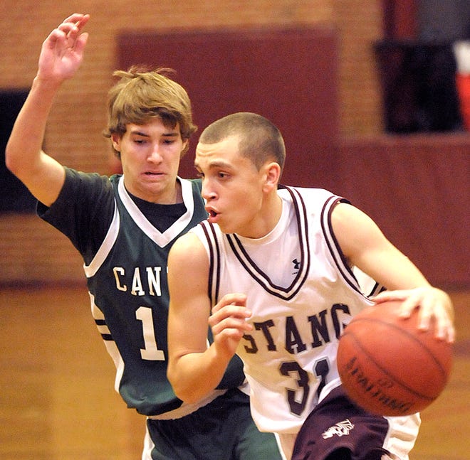 Bishop Stang's Thomas Keyes drives past Canton's Chris Murray in the first half of Tuesday's game. photo by jack foley