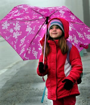 Ashley Tomaso of Hopkinton is prepared for the weather yesterday as she waits for a school bus with her father, Jeffrey. The bus will take her to Center School for afternoon kindergarten.